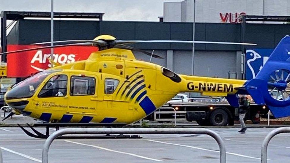 emergency services helicopter at shop car park