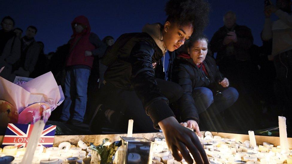 People lighting candles