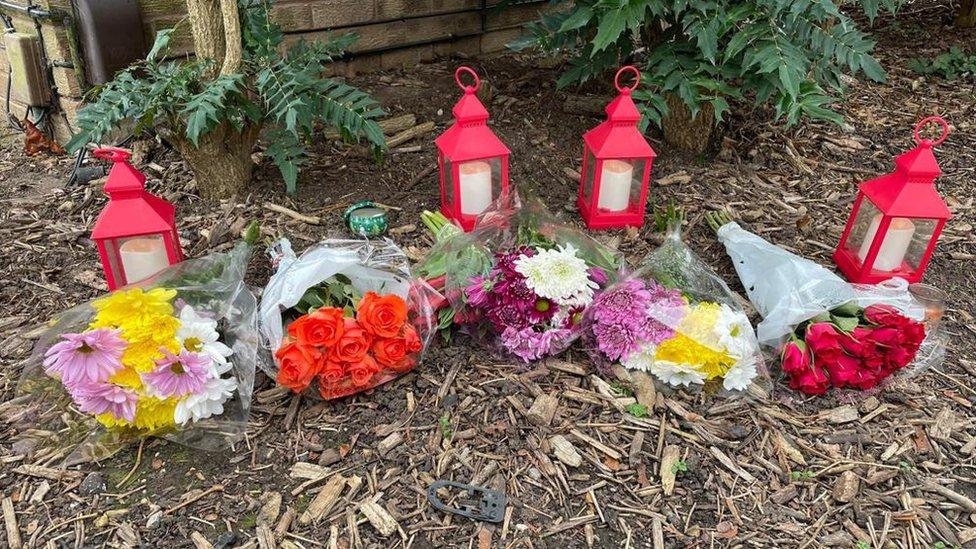 Flowers and candles at the scene in Tennyson road