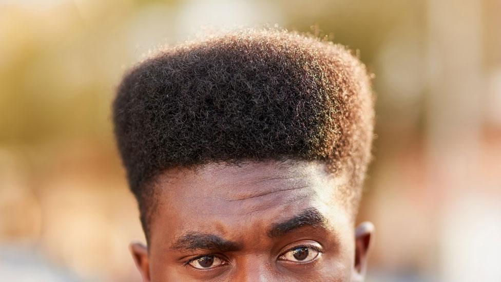 Man with big hair and raised eyebrow