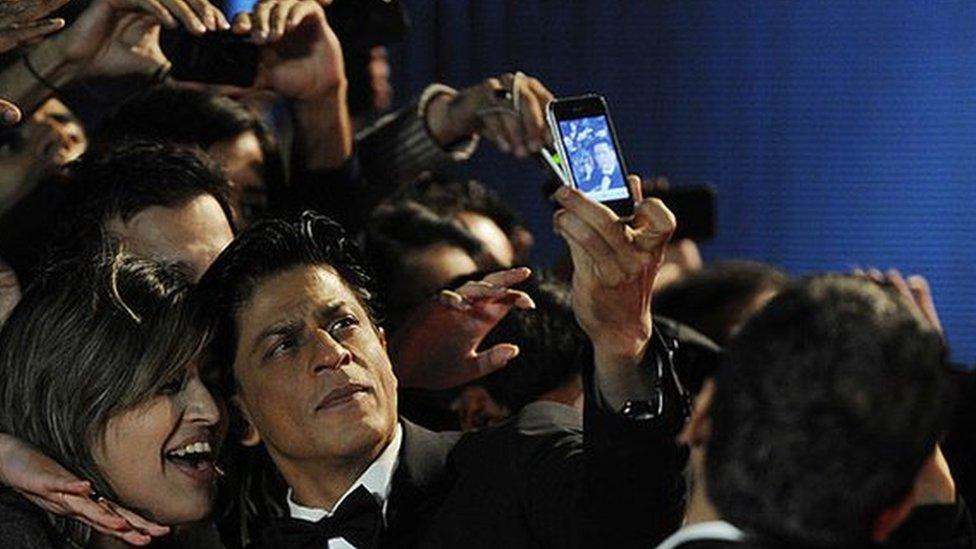 Actor Shah Rukh Khan poses with fans as he attends the UK premiere of Ra One at the O2 Arena on October 25, 2011.