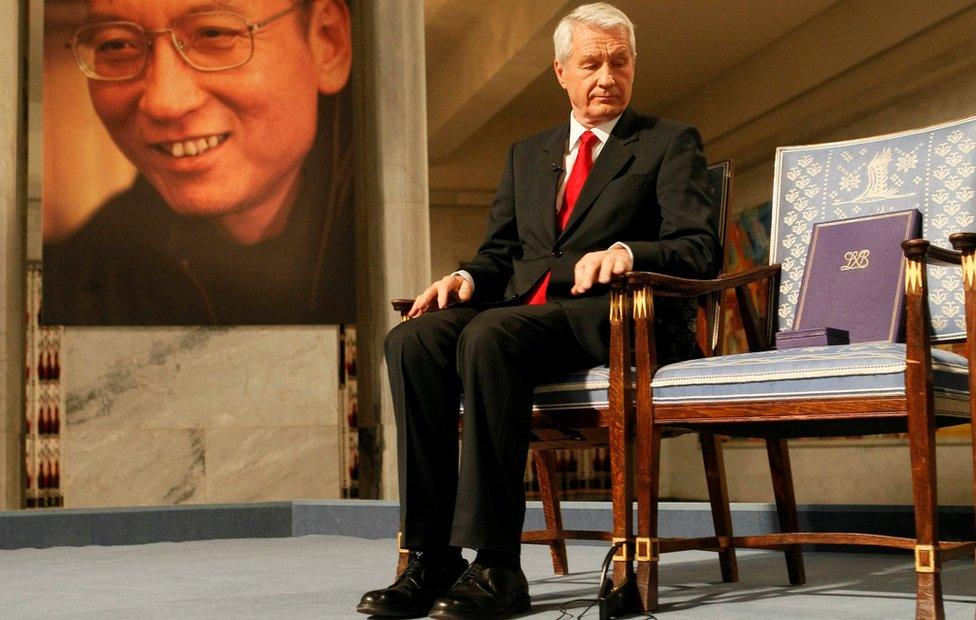 Chairman of Norwegian Nobel Committee Jagland looks down at Nobel certificate and medal on empty chair where Liu would have sat, in Oslo on 10 December 2010