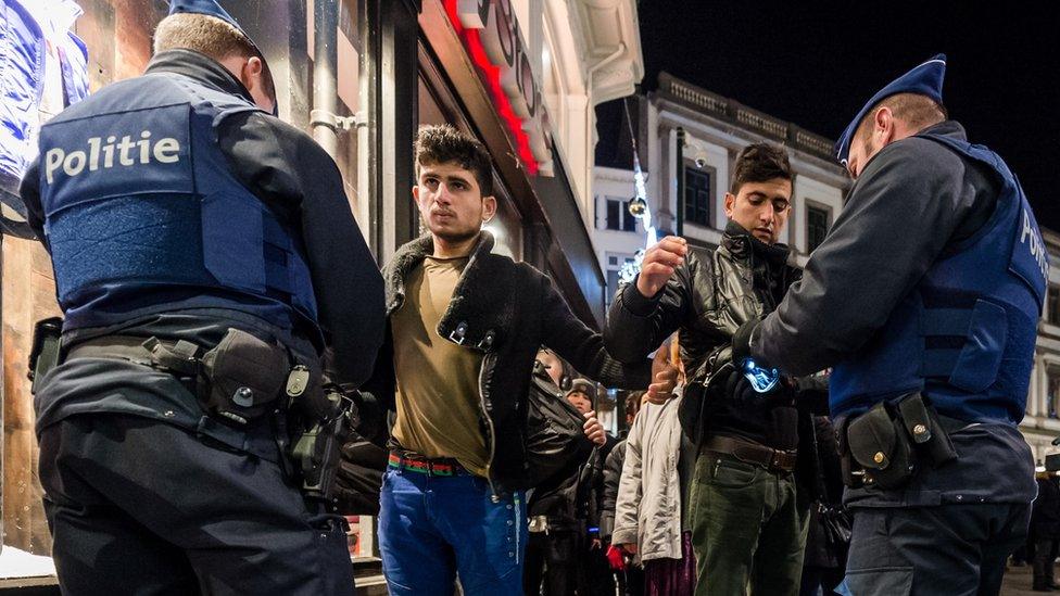 Police officers check people as they enter the Grand Place in Brussels on Thursday, Dec. 31, 2015