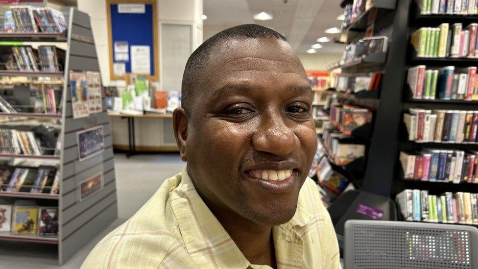 Dr Solomon Lebese smiling in a library