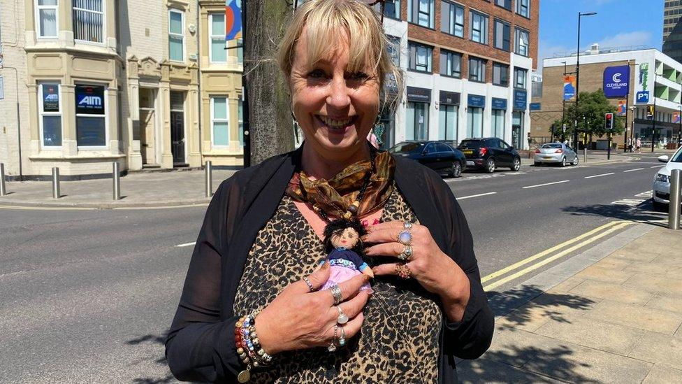 Sue Robson holds a doll