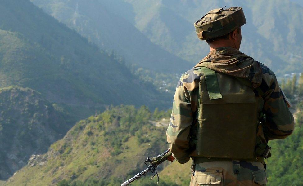 An Indian army soldier looks towards the site of a gun battle between Indian army soldiers and rebels inside an army brigade headquarters near the border with Pakistan, known as the Line of Control, in Uri. Taken on 18 September 2016.