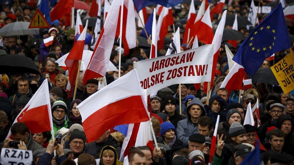 People hold up a banner that reads, "Jaroslaw (Kaczynski) leave Poland", during an anti-government demonstration in front of the Constitutional Court in Warsaw, Poland