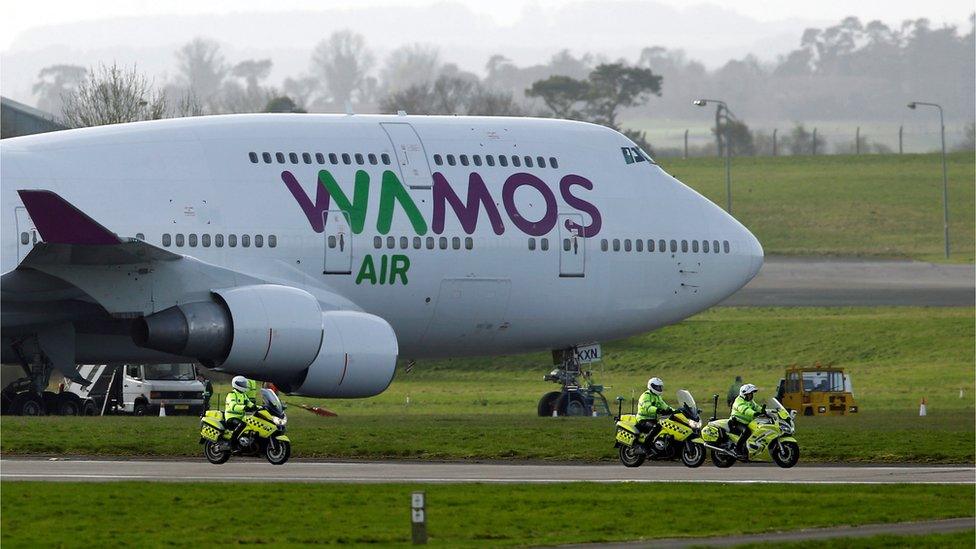 Police officers ride next to the plane