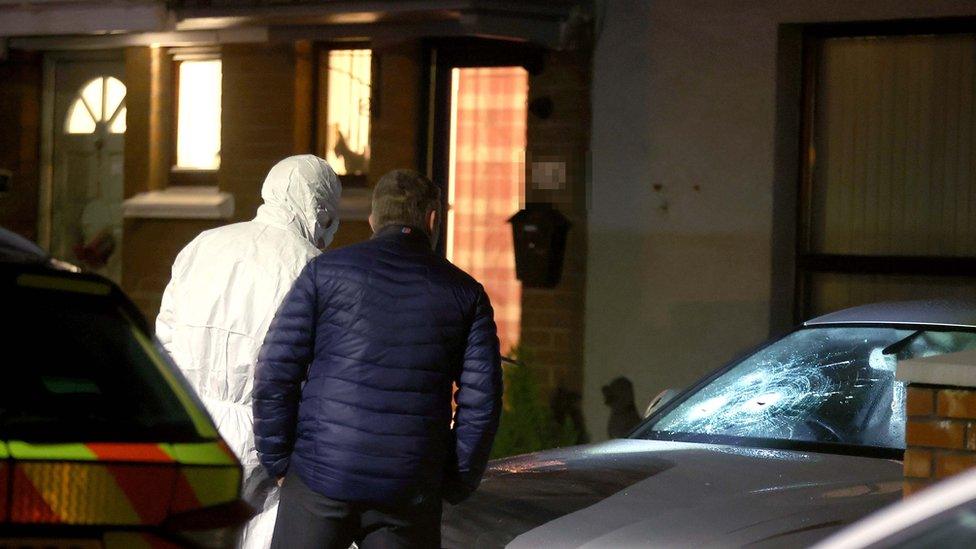 Forensic officer at the site beside car with smashed window