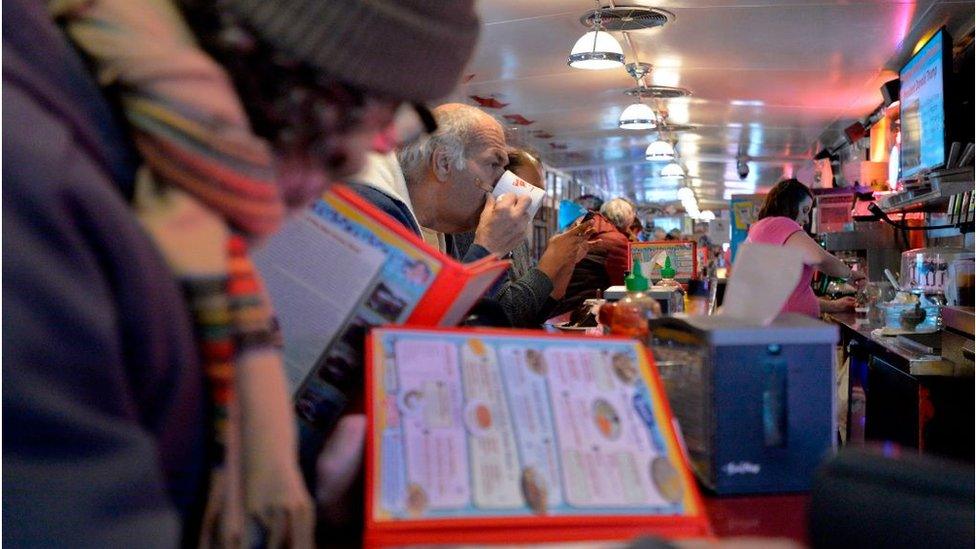 A woman serves customers in a diner in New Hampshire