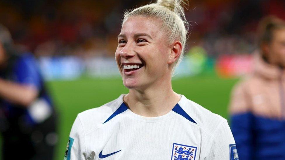 Bethany England of England during the FIFA Women's World Cup Australia & New Zealand 2023 Round of 16 match between England and Nigeria at Brisbane Stadium. Bethany is a 29-year-old white woman with long blonde hair tied in a bun at the top of her head. She wears the white England shirt complete with three lions logo and blue trim. She smiles into the crowd.