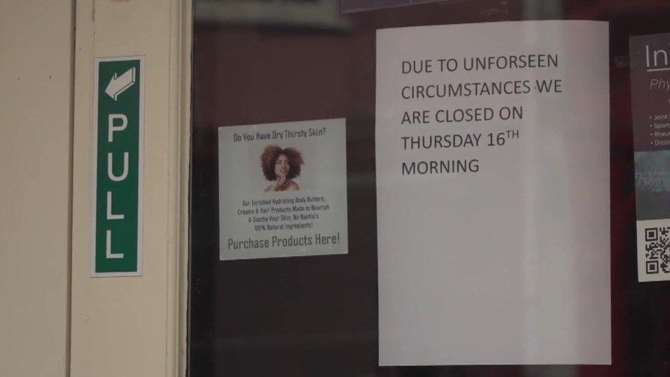 sign on pharmacy door which reads "due to unforseen circumstances we are closed on Thursday 16th morning"