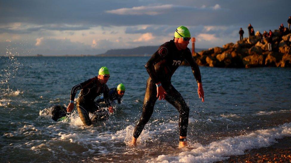 Participants exit the water as they finish the swim leg of the race during IRONMAN 70.3 Weymouth on September 17, 2017