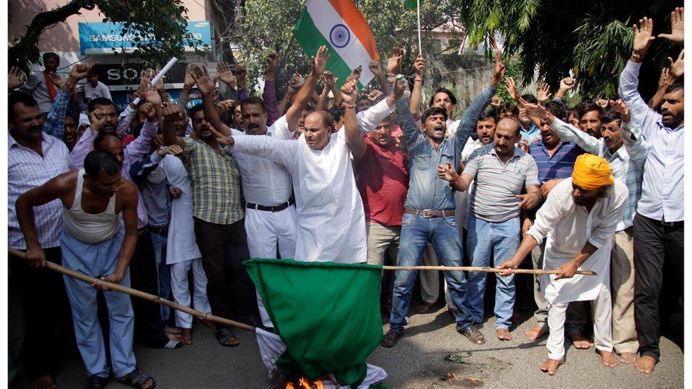 Indian nationalist activists burn a Pakistani flag in Jammu, India, as they protest the attack on Sunday 18 September.