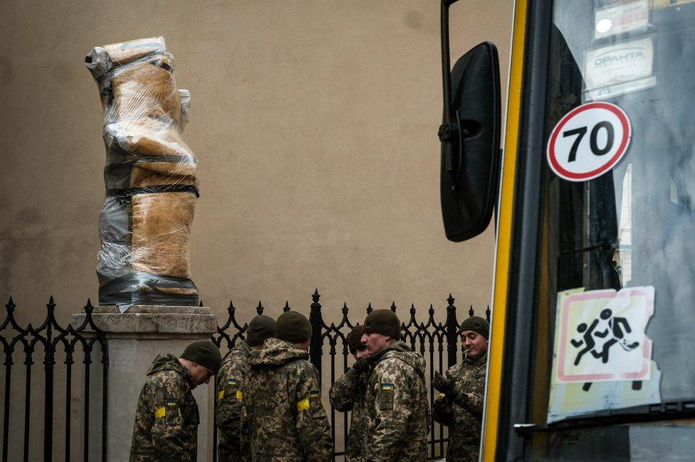 Territorial defence soldiers gathered outside a Lviv church where the statutes have been wrapped up