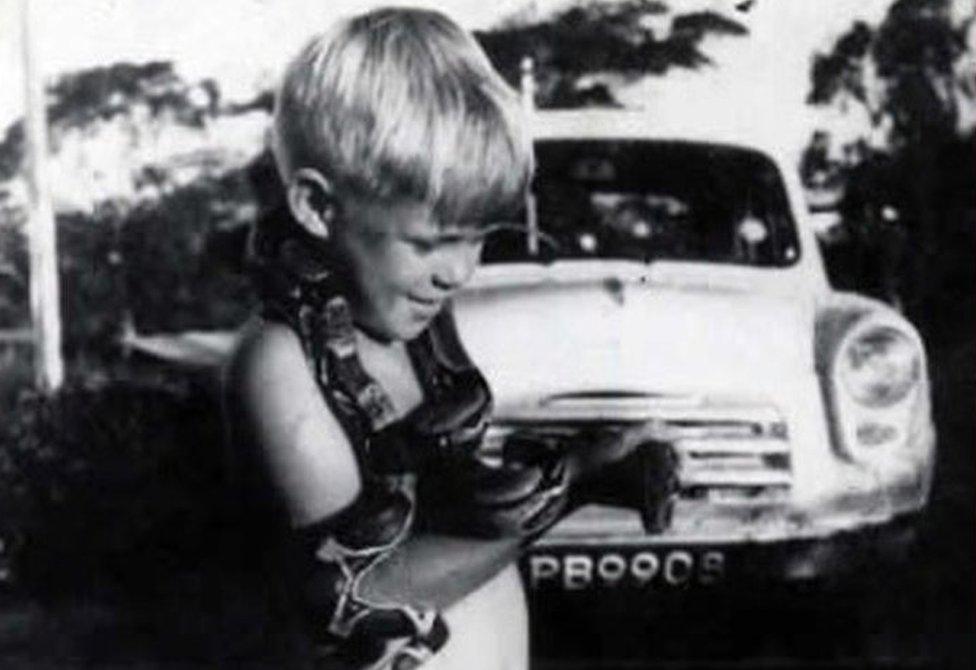 Mike Boston as a child with a snake around his neck