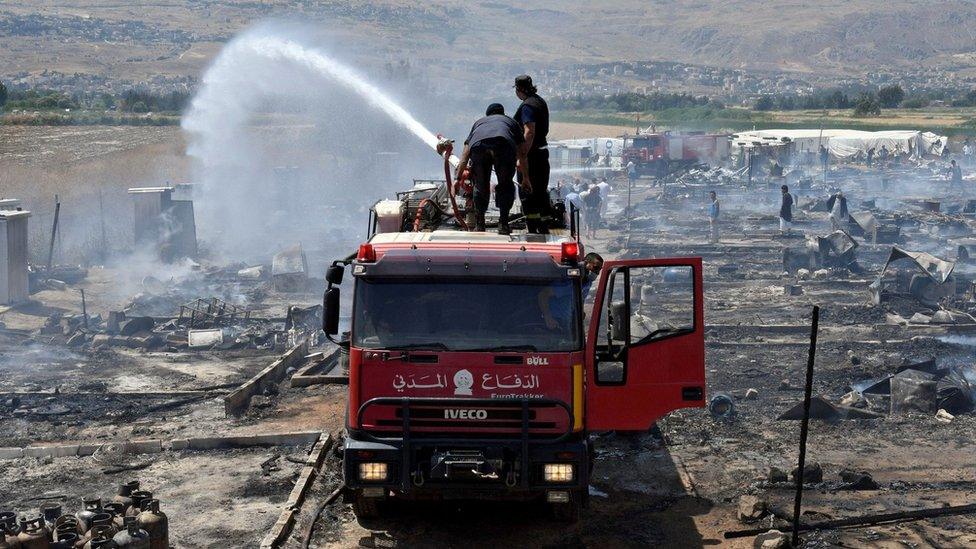 Firefighters put out fire at refugee camp in Lebanon on 2 July 2017