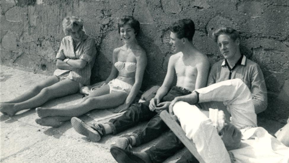 Sitting on the beach with friends in the 1950s