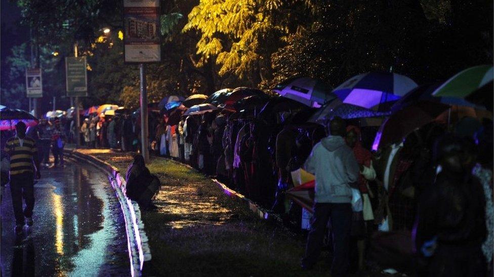 People queuing in the rain