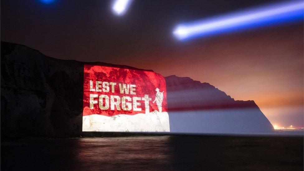 Image saying 'Lest we forget' projected onto the side of the White Cliffs at Dover