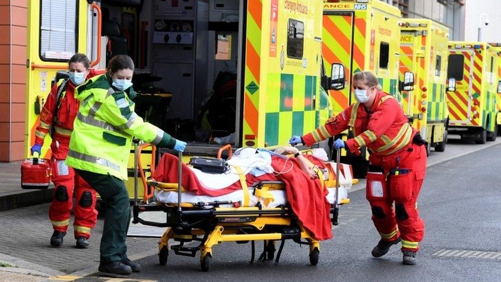 Ambulance workers assist a patient outside the Royal London Hospital in London