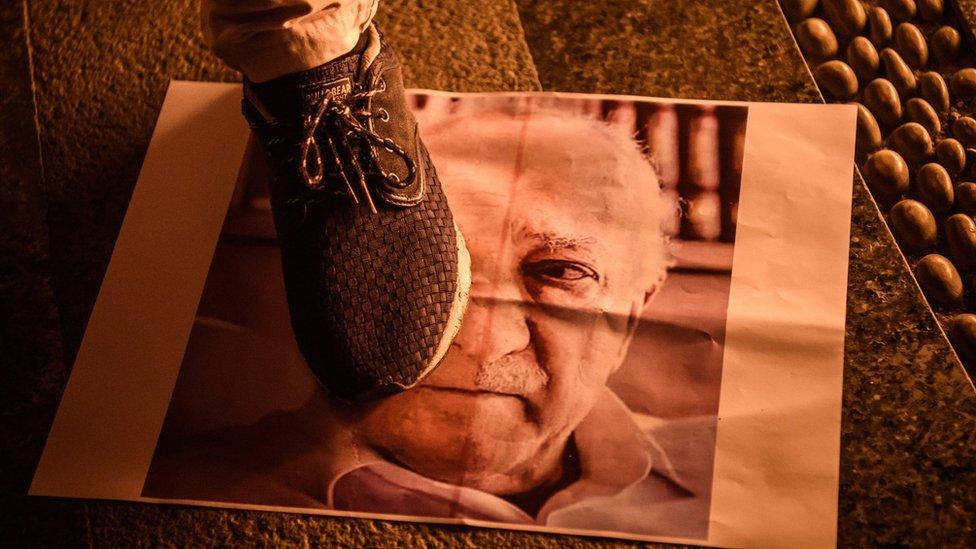 Pro-Erdogan supporter walks on poster picturing US-based preacher Fethullah Gulen during rally at Taksim square in Istanbul on July 18, 2016