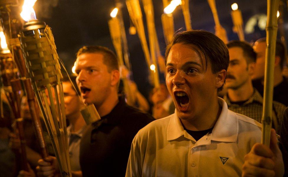 Peter Cvjetanovic seen yelling and holding a torch after marching through the University of Virginia campus