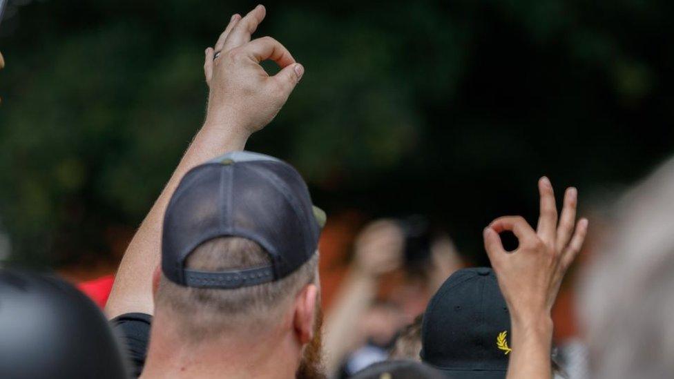 Protester holds up OK sign