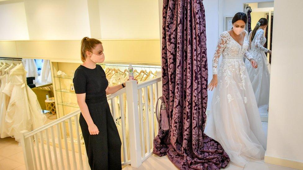 Jessica Letheren exits the fitting room after changing into a wedding dress assisted by bridal consultant Felicity Gray at Allison Jayne Bridalwear in Clifton, Bristol, which has reopened following the lifting of coronavirus lockdown restrictions, with measures put in place to prevent the spread of coronavirus during brides" dress fittings