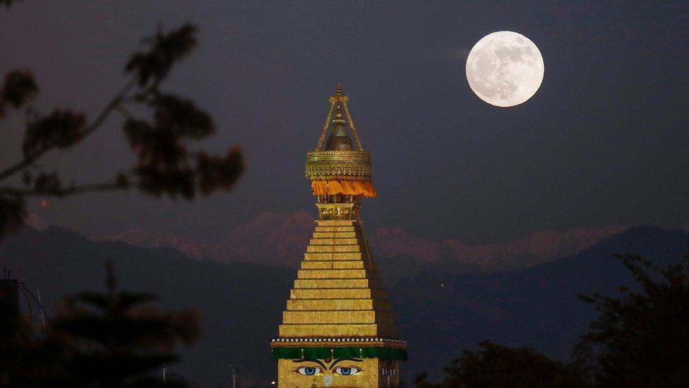 The moon rises over an upper portion of the Boudha stupa in Kathmandu, Nepal, 14 November 2016