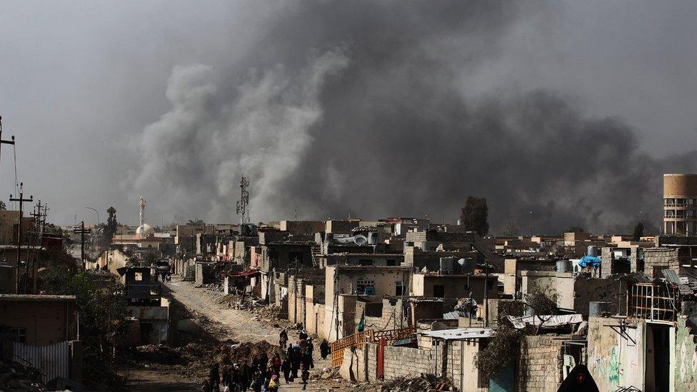 Iraqi families leave Mosul"s Nablus neighbourhood on March 12, 2017, during an offensive by security forces to retake the western parts of the city from Islamic State (IS) group fighters.