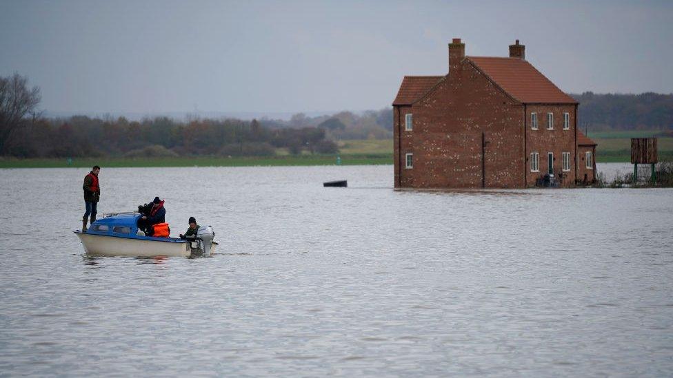 Mr Ward on a boat after his farm flooded in 2019