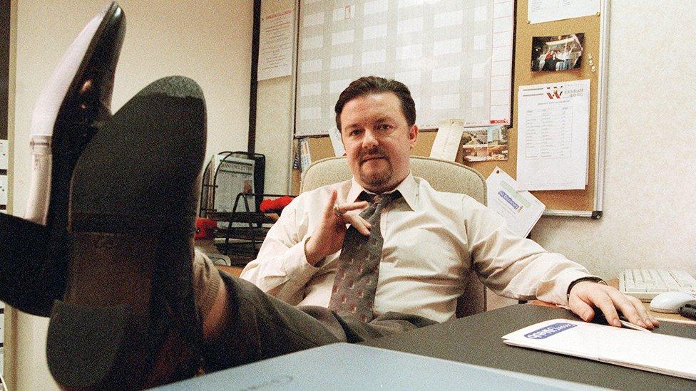 David Brent sat at his desk