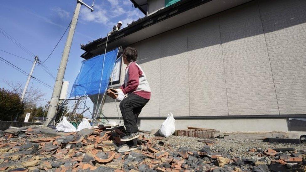 Residents collect belongings after an earthquake in Japan