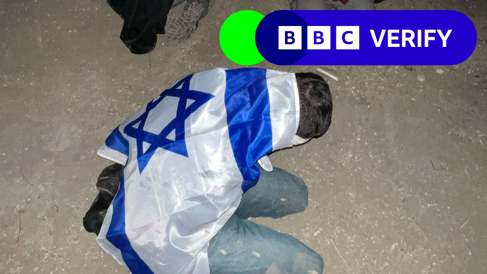 A Palestinian detainee pictured with an Israeli flag draped over their back