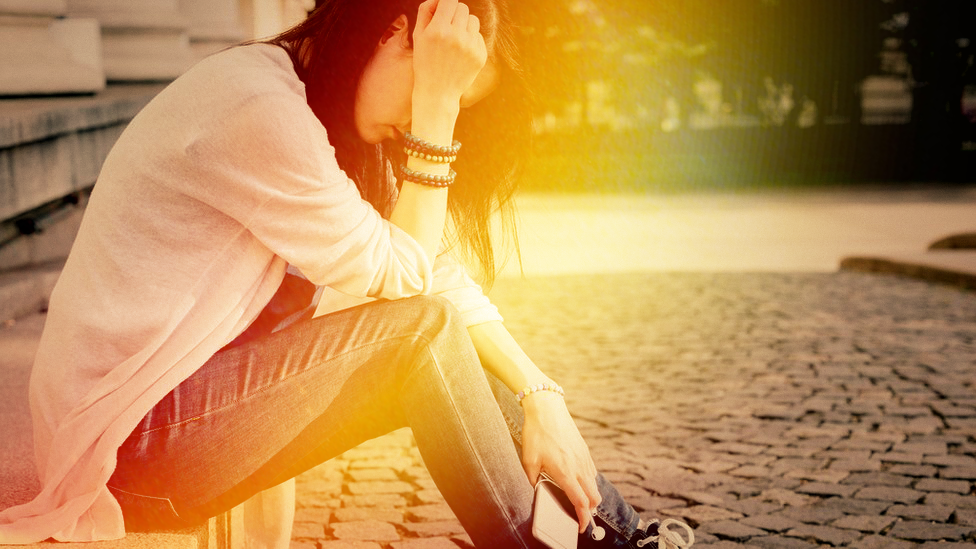 Anonymous woman holding phone (Library image)