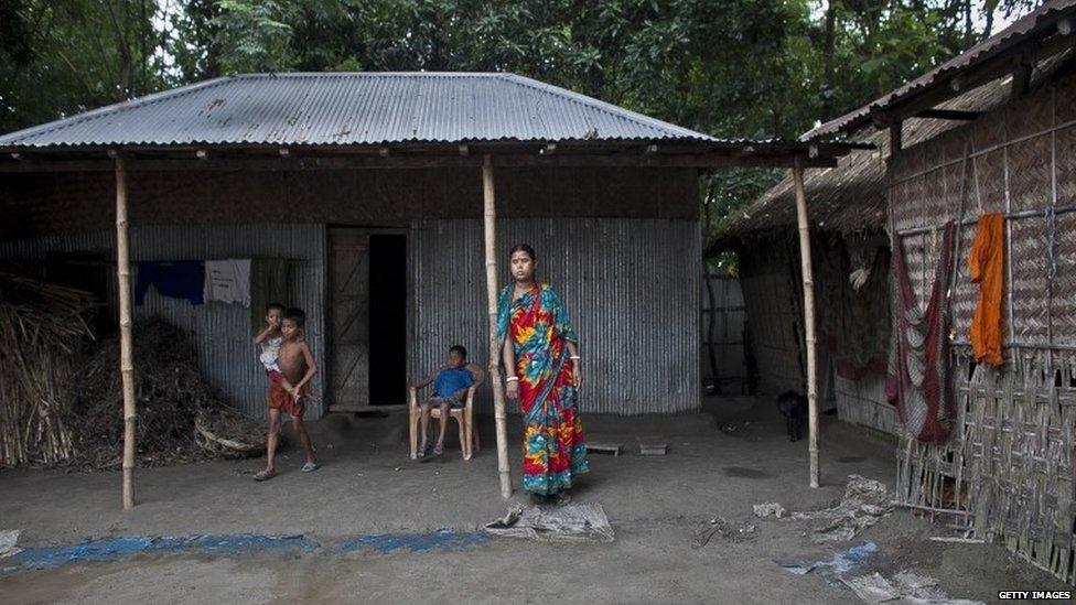 Gota Mari Indian enclave resident Shobita Rani stands outside her home July 10, 2015 in Lalmonirhat District, Bangladesh.