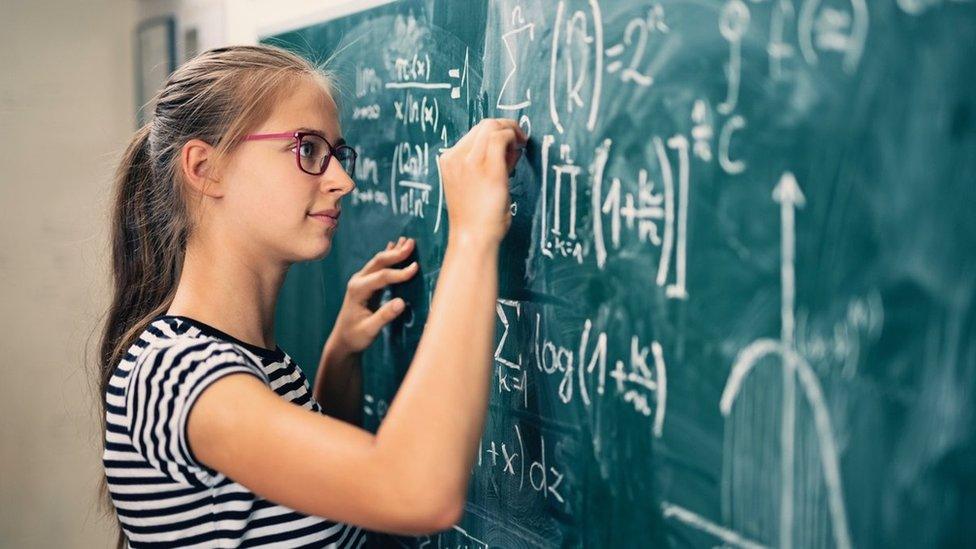 Girl writing on board