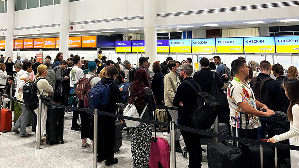 Travellers queue at Gatwick airport