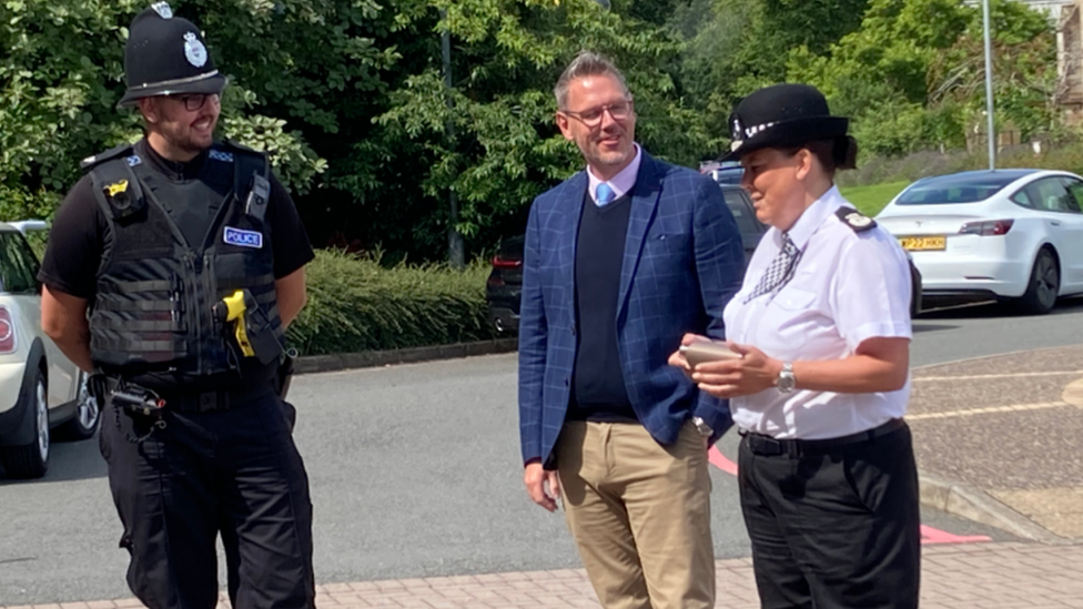 Ch Con Pippa Mills and PCC John Campion talking to an officer on the crime team