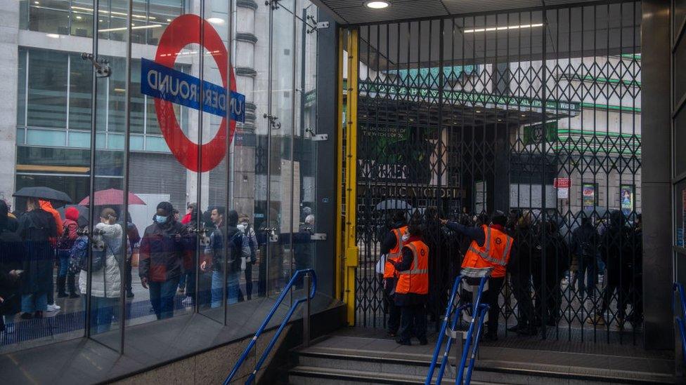 Commuters wait in long queues for buses at Victoria Train station as the underground is shut down