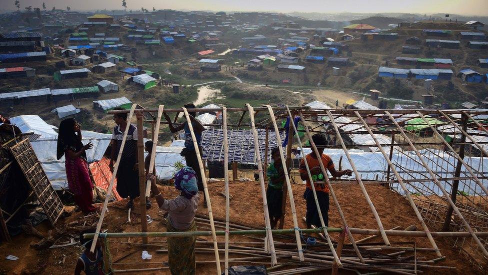 Rohingya refugee family rebuild a makeshift shelter at Balukhali refugee camp in the Bangladeshi district of Ukhia on November 22, 2017