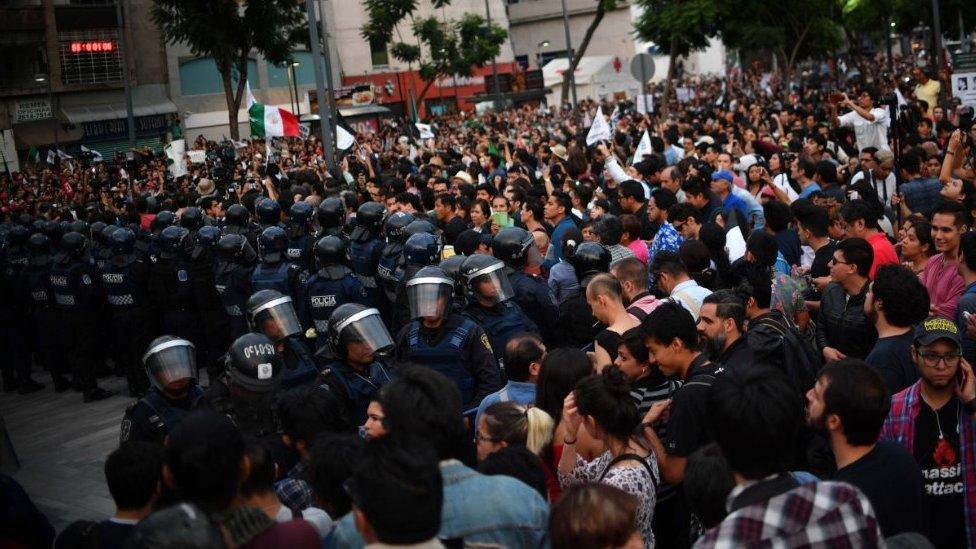 Riot police form a line to hold back the demonstration in Mexico City