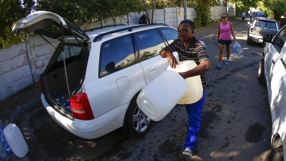 Residents of Cape Town carry plastic bottles to collect drinking water from a mountain spring collection point in Cape Town, South Africa, 17 January 2018.