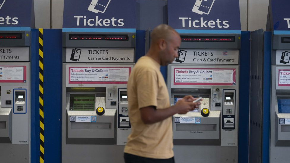 Man walks past ticket machines