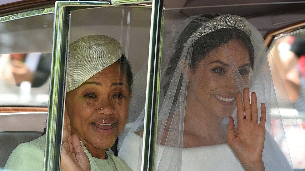 The duchess and her mom smile, seated in a car.