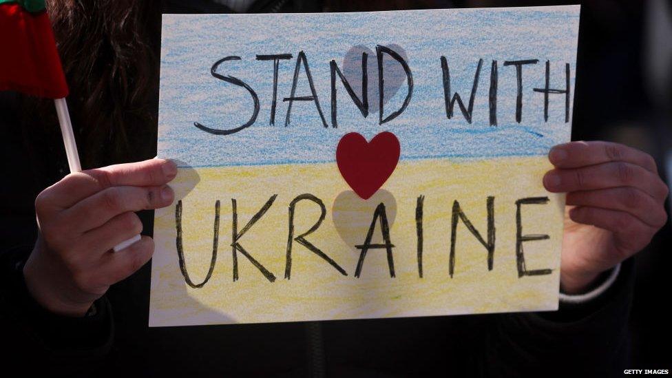 A photo of a sign saying 'Stand with Ukraine'