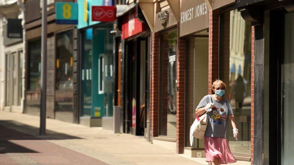 A woman wearing a mask walks down the High Street in Leeds