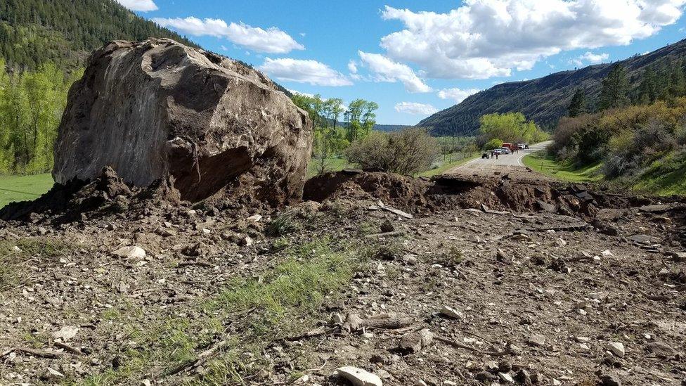 A huge boulder with the rest of the road in the distance