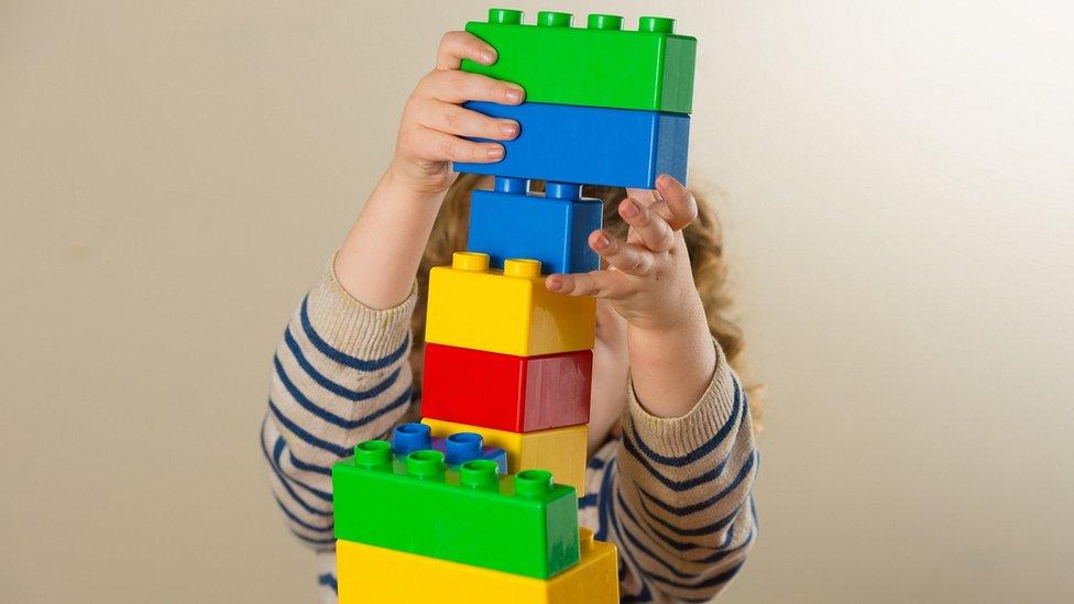 Child building lego tower